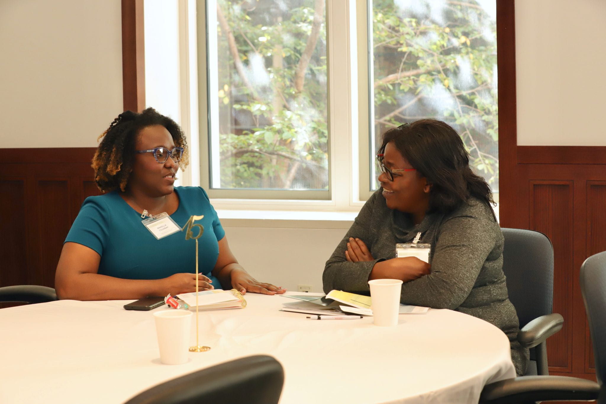 Dr. Coudray talks with a black woman at a table